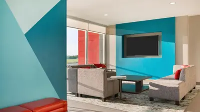 a living room with a couch and a tv at avid hotel - Ft Lauderdale Airport - Cruise by IHG in Fort Lauderdale