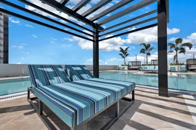 a bench on a patio next to a swimming pool at Luxury 2BD Apartment in Downtown Doral in Miami