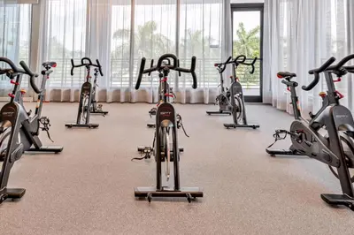 a bunch of exercise bikes in a gym at Luxury 2BD Apartment in Downtown Doral in Miami