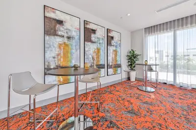 a room with two tables and chairs and paintings on the wall at Luxury 2BD Apartment in Downtown Doral in Miami