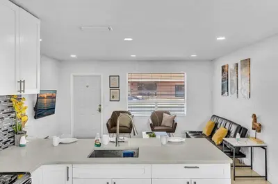 a kitchen with a counter and chairs in a room at Modern 2br Near Aventura Mall & Sunny Beach in Hallandale Beach