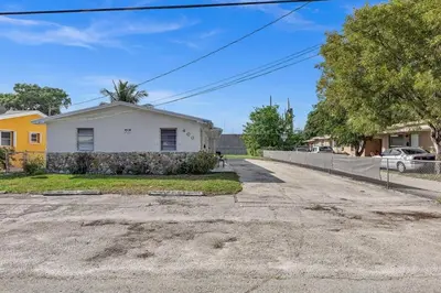 an empty street in front of a white house at Modern 2br Near Aventura Mall & Sunny Beach in Hallandale Beach