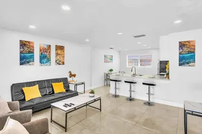 a living room with a couch and a kitchen at Modern 2br Near Aventura Mall & Sunny Beach in Hallandale Beach