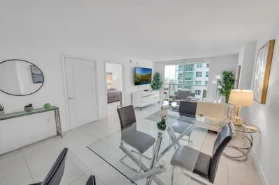 a living room with a glass table and chairs at Luxury 1 Bedroom Apartment • Brickell • Unique Views in Miami