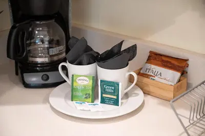 two coffee mugs on a plate on a counter at Casa Del Mar Master in Hollywood