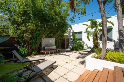 a patio with chairs and a couch and trees at Casa Del Mar Master in Hollywood