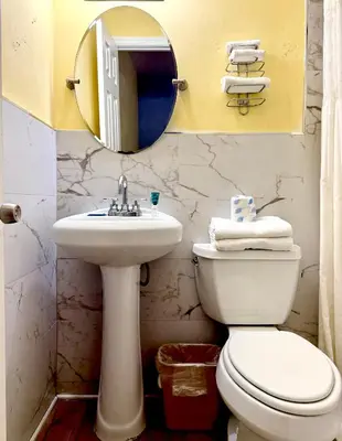 a bathroom with a sink and a toilet and a mirror at Crown Inn in Fort Lauderdale