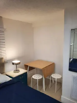 a bedroom with a bed and a table and two stools at 1161 Studio 2 Main Miami in Miami