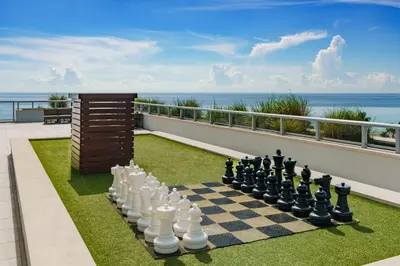 a chess board on a lawn with the ocean in the background at Costa Hollywood Beach Resort - An All Suite Hotel in Hollywood