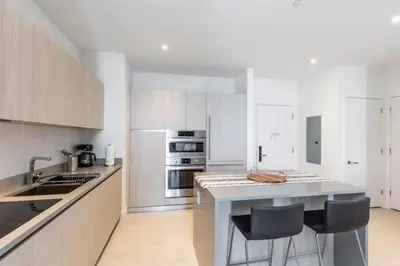 a kitchen with white cabinets and a counter with bar stools at Hyde Beach House Luxury Condo-Resort condo in Hollywood Beach