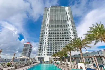 a large white building with palm trees and a swimming pool at Hyde Beach House Luxury Condo-Resort condo in Hollywood Beach