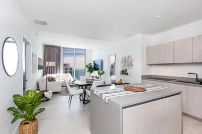 a kitchen and living room with white cabinets and a table at Hyde Beach House Luxury Condo-Resort condo in Hollywood Beach