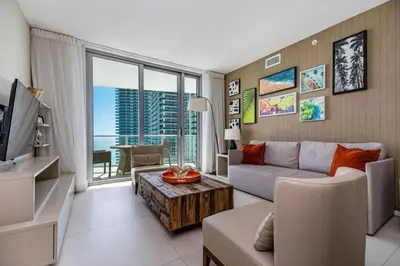 a living room with a couch and a tv at Hyde Beach Luxury Condo-Resort apts in Hollywood Beach