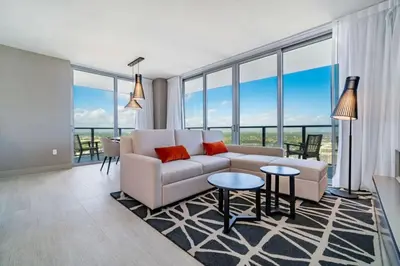 a living room with a couch and tables and windows at Hyde Beach House Luxury Condo-Resort condo in Hollywood Beach