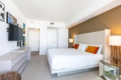 a white bedroom with a large bed and a television at HYDEOV1BR - Unit 1910 - Ammos condo in Hollywood Beach
