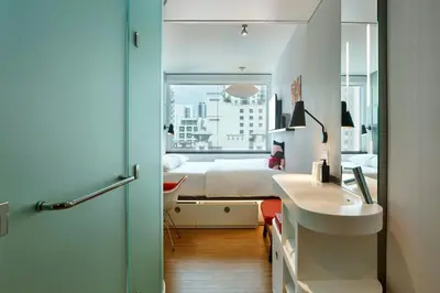 a bathroom with a sink and a bedroom with a bed at citizenM Miami Brickell in Miami