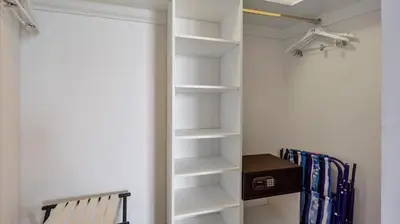 a walk in closet with white shelves and a drawer at 2 bed rental on the beach15th floor Hollywood Miami in Hallandale Beach