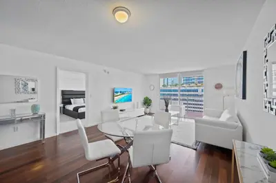 a living room with a glass table and white chairs at Private Unit Miami With Amenities And Parking in Miami