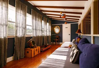 a living room with a purple couch and windows at The Captain's Landing - 4 bedroom - 2 bathroom - Outdoor soaking tub - Adventure home in Fort Lauderdale