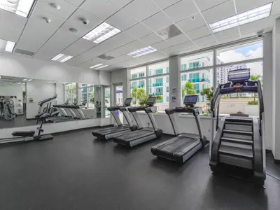a gym with rows of treadmills and elliptical machines at Spectacular apartment in Heart of Brickell in Miami