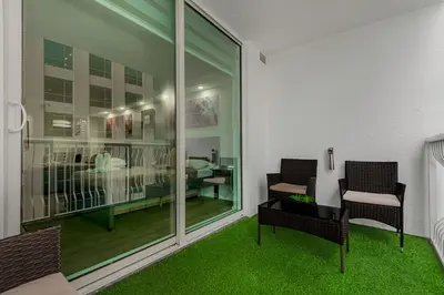 a room with two chairs and a room with green carpet at High Rise Brickell Modern Studio in Miami