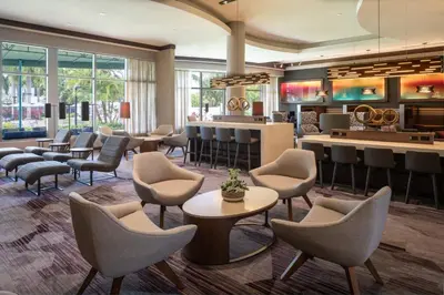 a lobby of a hotel with chairs and a bar at Courtyard by Marriott Miami Airport in Miami