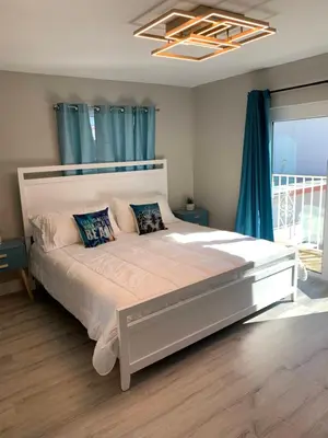a bedroom with a large white bed with blue curtains at The Tel in Hollywood
