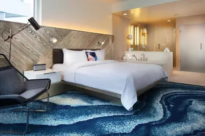 a hotel room with a large bed and a chair at W Fort Lauderdale in Fort Lauderdale