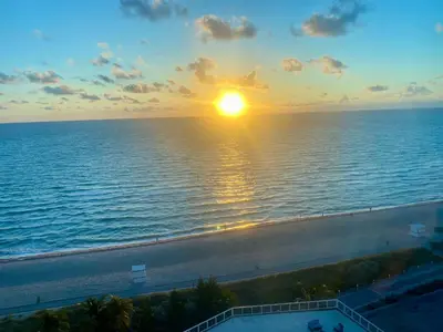 a view of the ocean with the sun setting over the ocean at Castle Beach Resort Condo - Panoramic Large Penthouse or Deluxe 1 BR Direct Ocean View and beach access- Updated-Free parking- in Miami Beach