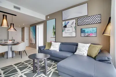 a living room with a blue couch and a table at Upscale Condo with Pool Access in Hyde Beach House! in Hollywood