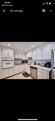 a kitchen with white cabinets and white appliances at Apartments TVG Miami by the ocean ! in Miami Beach