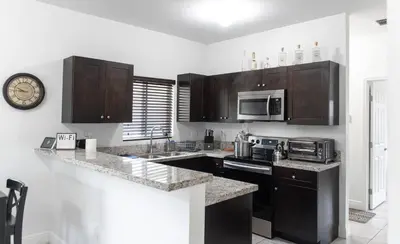 a kitchen with wooden cabinets and a counter top at New house on the block near Miami Airport. in Miami