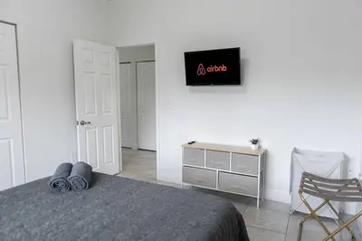 a bedroom with a bed and a dresser with a sign on the wall at New house on the block near Miami Airport. in Miami