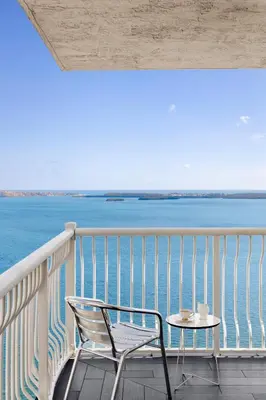 a chair and a table on a balcony overlooking the water at Brickell Apartments with Oceanview in Miami