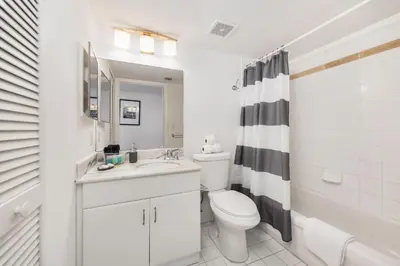 a white bathroom with a sink and a toilet at Brickell Apartments with Oceanview in Miami