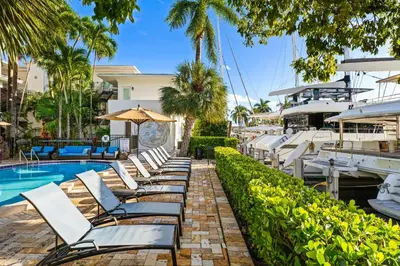 a row of chaise lounge chairs next to a swimming pool at Isle of Venice Residence and Marina in Fort Lauderdale