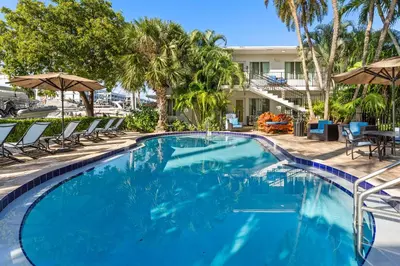 a swimming pool with chairs and umbrellas at a resort at Isle of Venice Residence and Marina in Fort Lauderdale