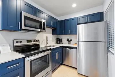 a kitchen with blue cabinets and a stainless steel refrigerator at Isle of Venice Residence and Marina in Fort Lauderdale