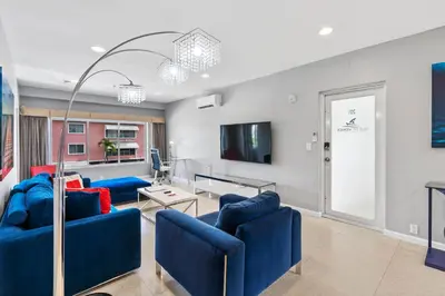 a living room with blue couches and a flat screen tv at Isle of Venice Residence and Marina in Fort Lauderdale