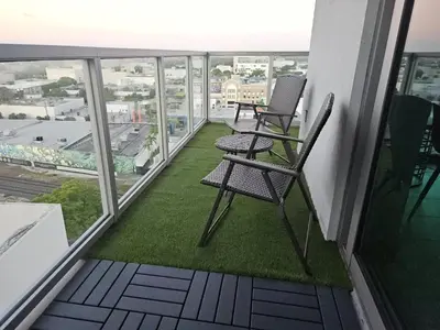 a balcony with two chairs and grass on a building at Desing district, great apartment in Miami