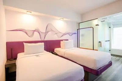 two beds in a room with a mural on the wall at YOTEL Miami in Miami