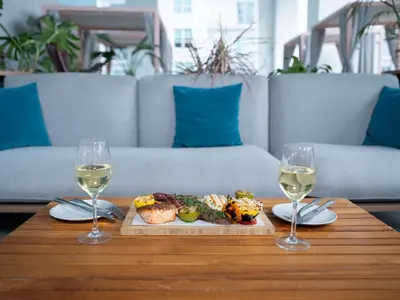 a table with a plate of food and two glasses of wine at YOTEL Miami in Miami
