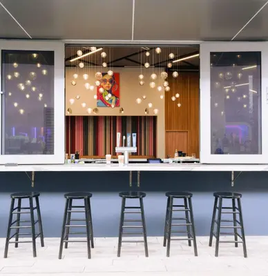 a bar with stools in front of a blue wall at YOTEL Miami in Miami
