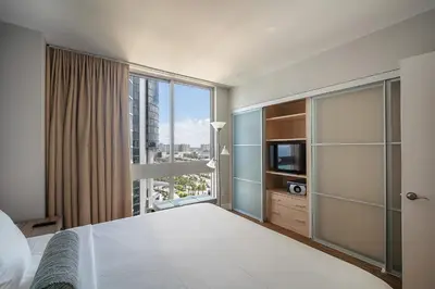 a bedroom with a bed and a large window at Sunny Isles 1BDR Sea View and Pool in Miami Beach