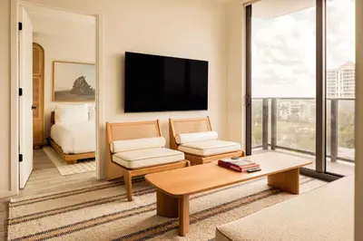 a living room with a couch and a tv at Flow Hotel Fort Lauderdale in Fort Lauderdale