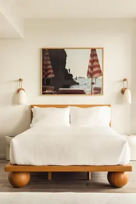 a bedroom with a white bed with a wooden headboard at Flow Hotel Fort Lauderdale in Fort Lauderdale