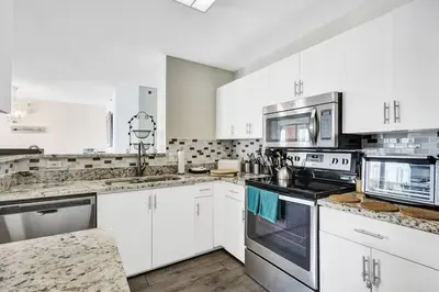 a kitchen with white cabinets and stainless steel appliances at Yacht Club at aventura Amazing Marina view parking included in Miami