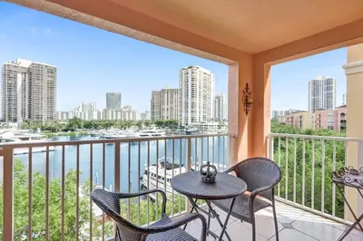 a balcony with a table and chairs and a view of the water at Yacht Club at aventura Amazing Marina view parking included in Miami