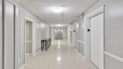 a hallway in a building with white walls and white floors at SeaStays Apartments in Miami Beach