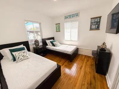 a bedroom with two beds and a couch in it at Hammocks & mini-golf! 10 mins from Beach! in Hollywood